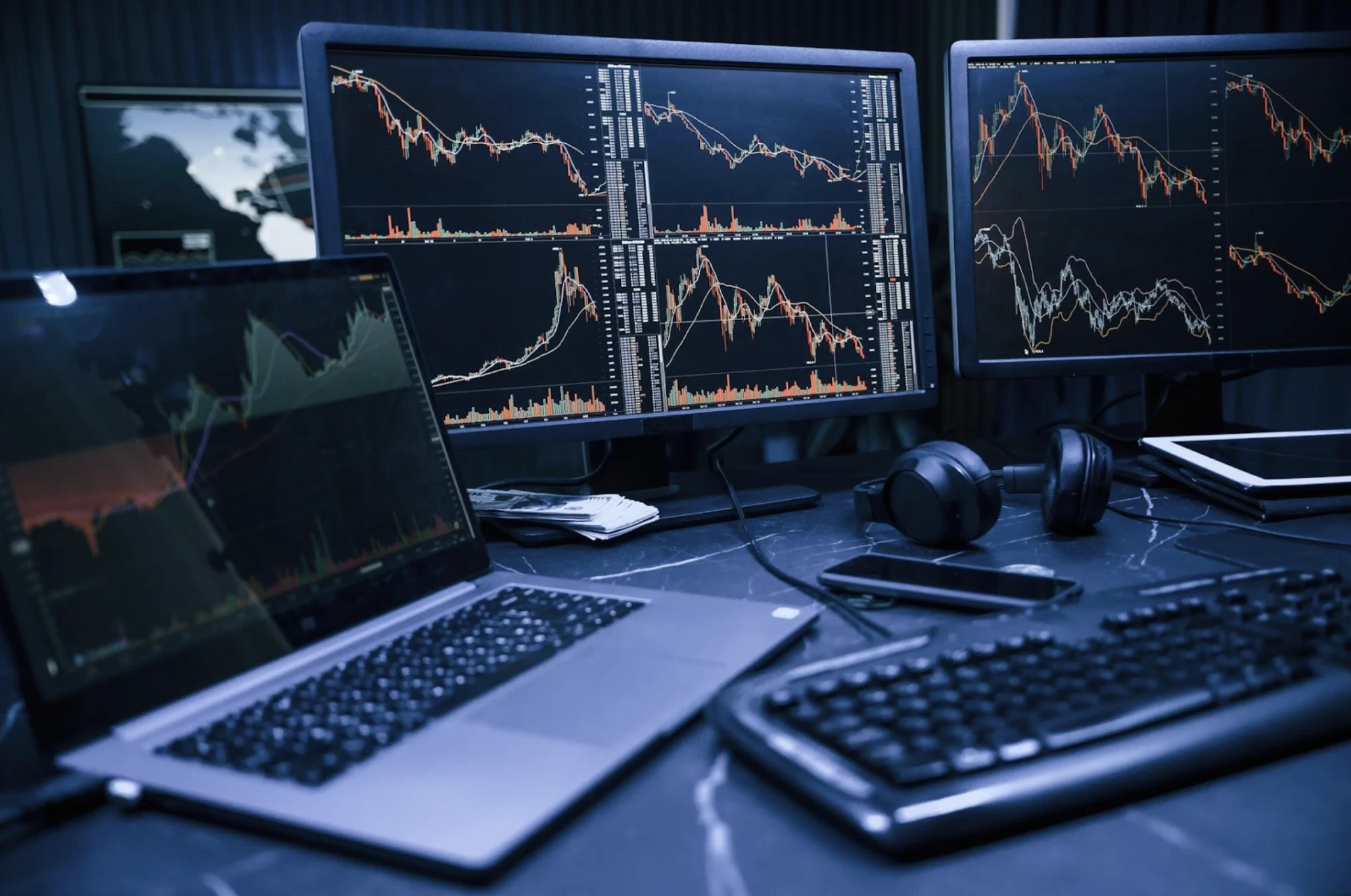 Pénzügyi elemző munka egy laptop outletből származó, többmonitoros professzionális munkaállomással.